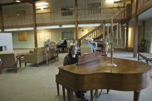 Senior playing the piano and enjoying the lifestyle at Arbor Court